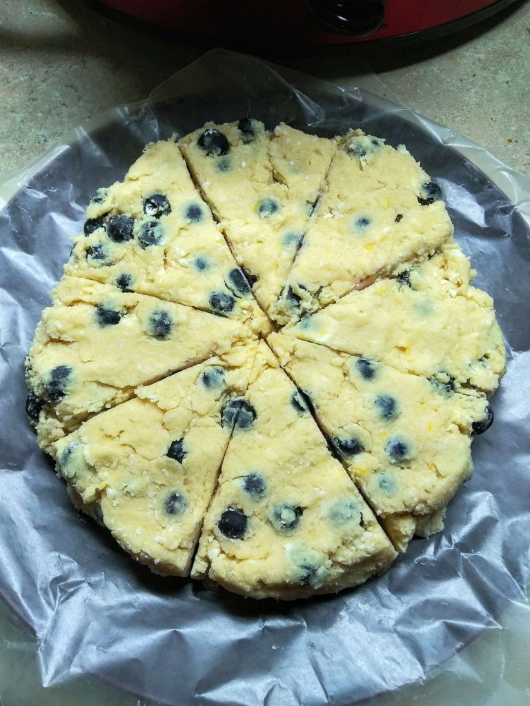 disc of raw lemon blueberry scones cut into 8 pieces