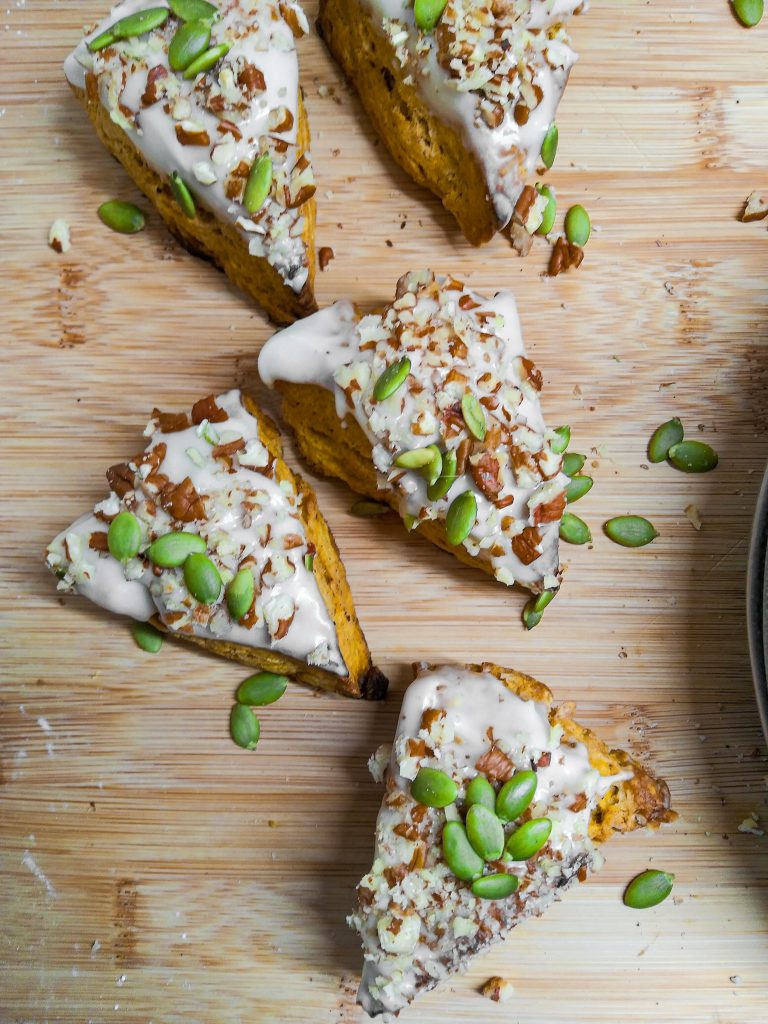 pumpkin scones topped with maple icing, pepitas, and crushed nuts.