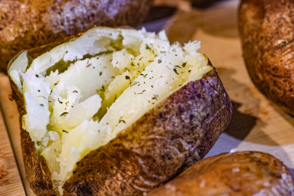 baked potato cooked in an air-fryer, split open and fluffed. 