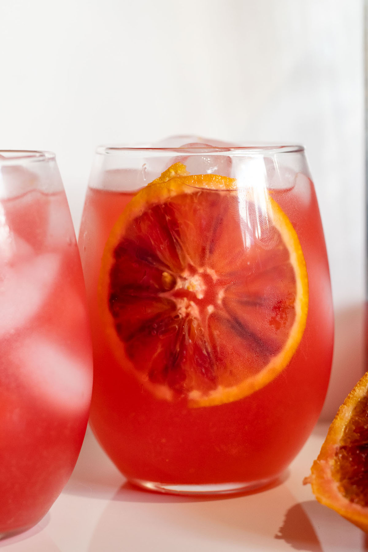 Crisp and refreshing blood orange lemonade with a slice dipped in.