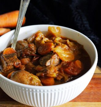 Bowl of cabbage soup with beef, carrots and tomatoes.